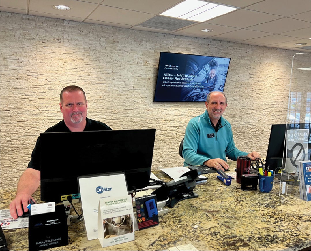 Friendly staff greeting with a smile behind the front desk working